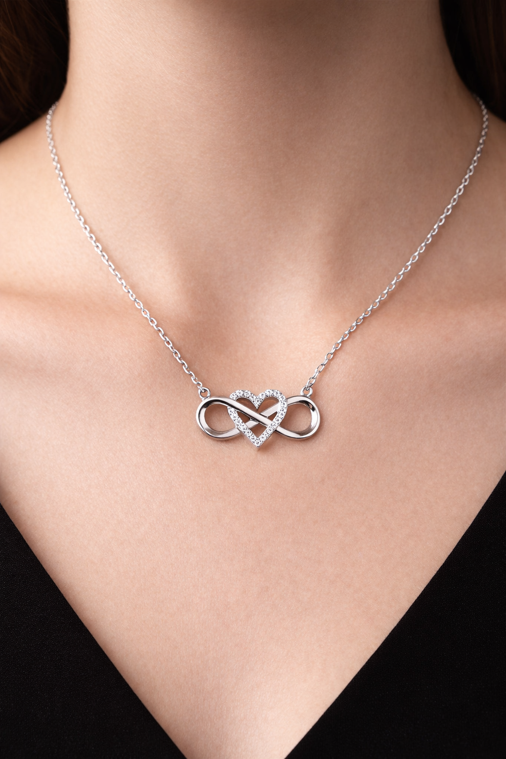 Close up of silver infinity heart pendant with zircon stone showing intricate design