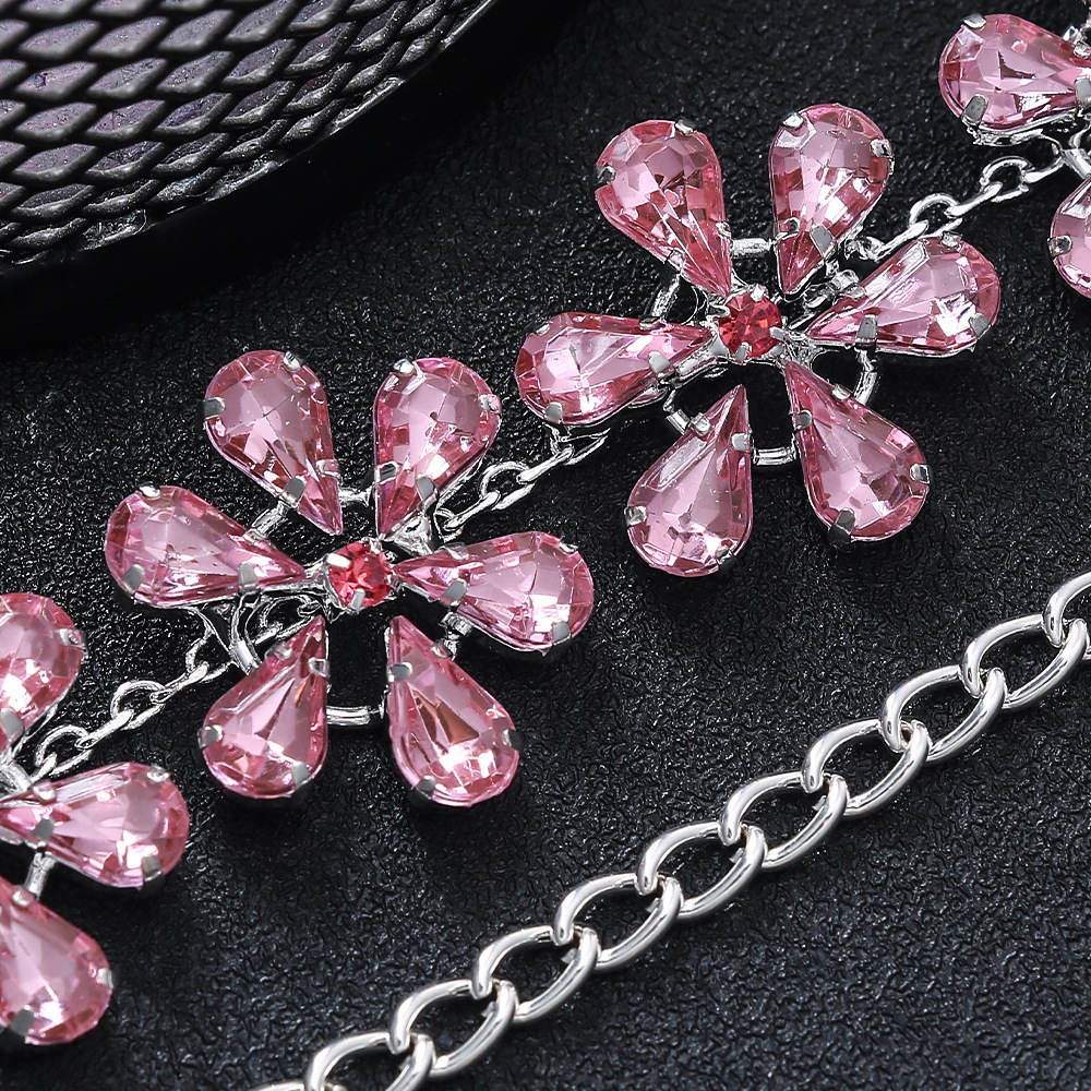 Alphalurent gold-plated choker necklace featuring linked crystal flowers with pink rhinestone petals.