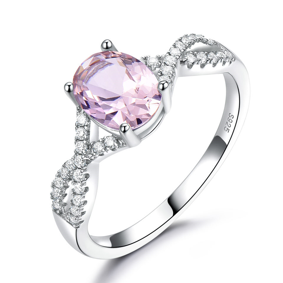 Alphalurent Infinity Azure Ring – Oval-Cut Sapphire Blue Crystal in S925 Model_s Hand Alphalurent 925 sterling silver ring featuring a vibrant oval-cut crystal center stone on a sparkling twisted infinity band, shown surrounded by white pearls. Available in blue, green, light blue, pink, and white.
