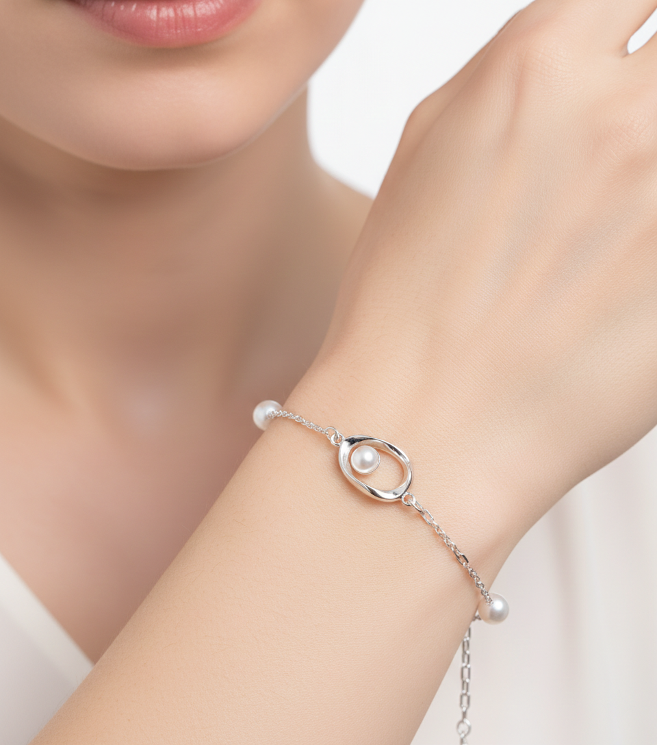 Alphalurent 925 silver necklace featuring a geometric Möbius twist pendant holding a single white pearl. (For the gold bracelet image): Gold-plated Alphalurent bracelet with a twisted pearl charm and two accent pearls on a delicate chain.