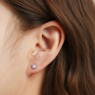 Alphalurent 925 sterling silver stud earrings featuring a heart-shaped iridescent blue opal crystal, a beaded silver edge, and comfortable screw-on ball backs.