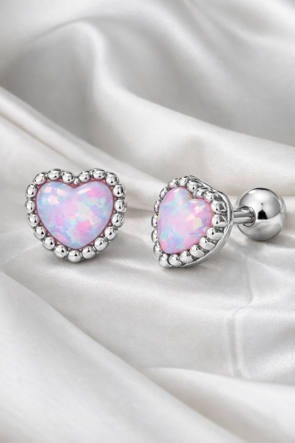 Alphalurent 925 sterling silver stud earrings featuring a heart-shaped iridescent blue opal crystal, a beaded silver edge, and comfortable screw-on ball backs.