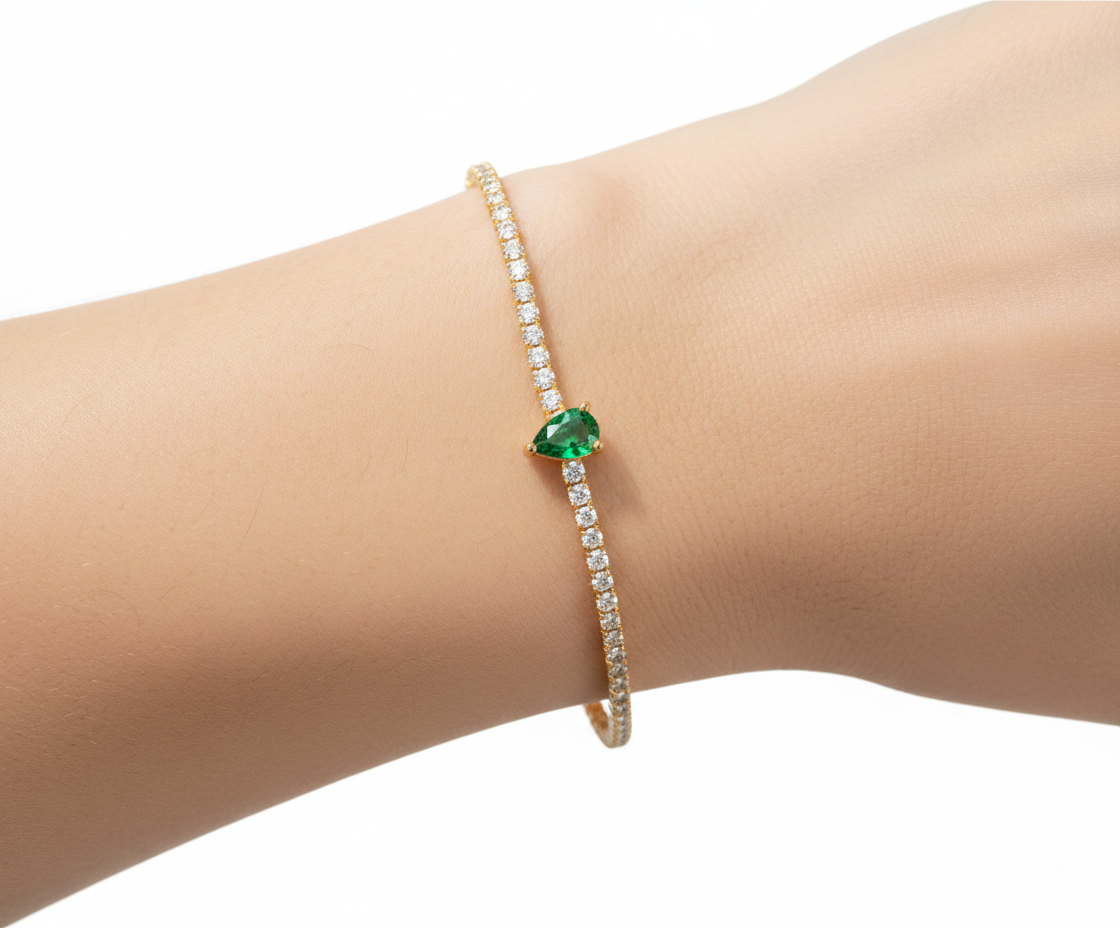 Alphalurent gold tennis bracelet featuring a single heart-shaped red zircon stone. (For the green image): Alphalurent gold vermeil tennis bracelet with a teardrop pear-shaped emerald green zircon.