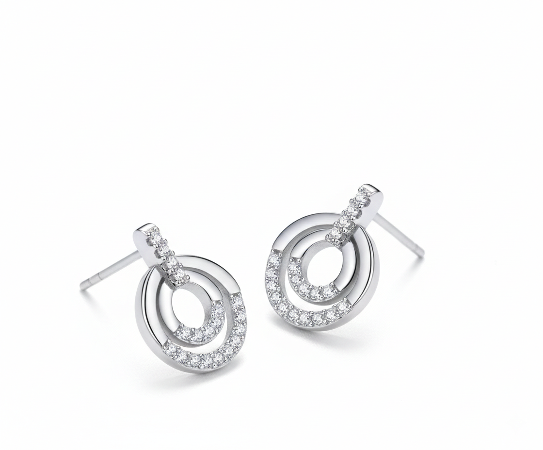 Alphalurent 925 sterling silver stud earrings featuring a geometric design with two interlocking circles, accented with sparkling pave crystals.