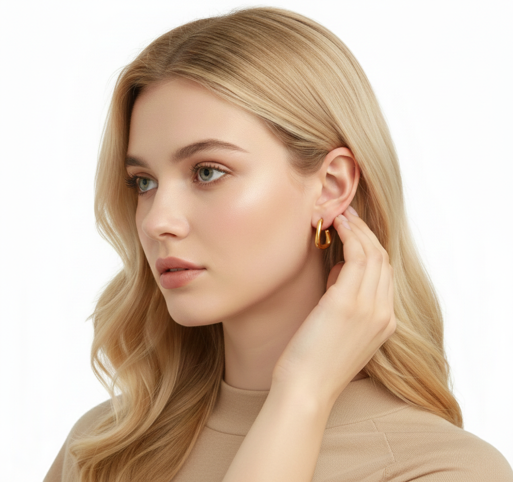 Alphalurent gold titanium steel hoop earrings featuring an irregular, fluid U-shape geometric design. (For the silver image): Model wearing Alphalurent asymmetric silver U-shaped hoop earrings with a sleek, modern finish.