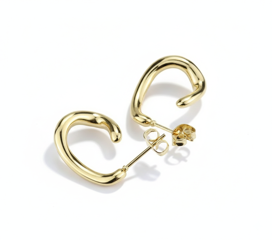 Alphalurent gold titanium steel hoop earrings featuring an irregular, fluid U-shape geometric design. (For the silver image): Model wearing Alphalurent asymmetric silver U-shaped hoop earrings with a sleek, modern finish.
