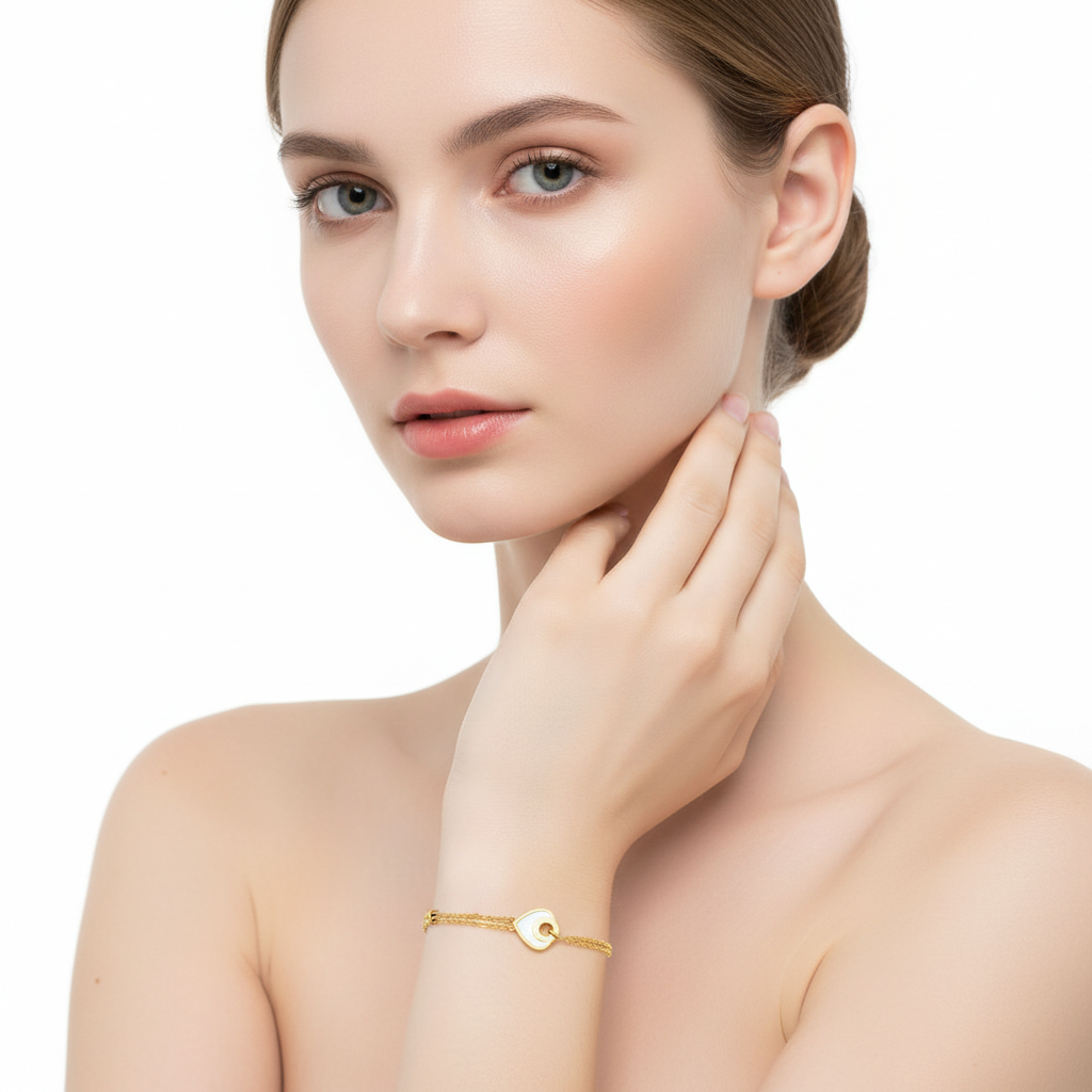 Alphalurent gold titanium steel bracelet featuring a double-strand chain with small tube beads and a white shell heart charm.