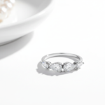 Alphalurent 925 sterling silver ring featuring five sparkling pear-cut cubic zirconia stones arranged in a row. (For the model images): Model wearing a delicate Alphalurent 925 silver 5-stone teardrop crystal ring.