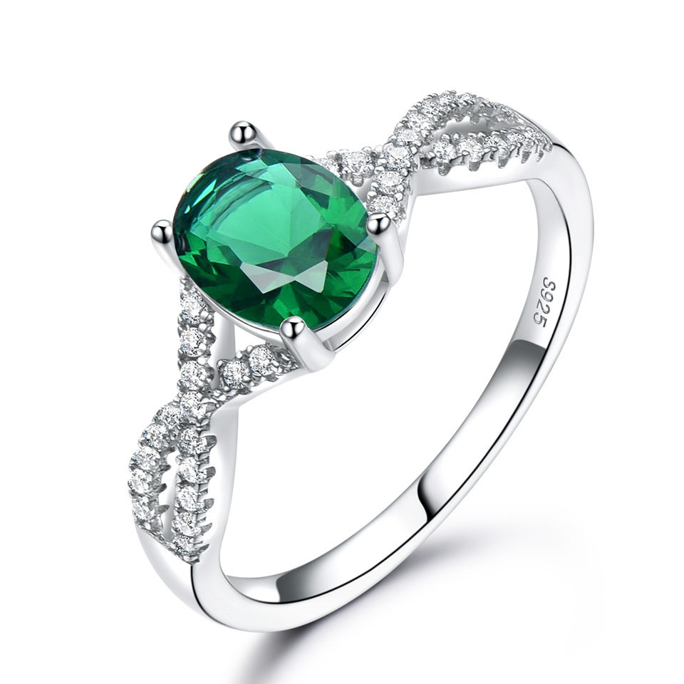 Alphalurent Infinity Azure Ring – Oval-Cut Sapphire Blue Crystal in S925 Model_s Hand Alphalurent 925 sterling silver ring featuring a vibrant oval-cut crystal center stone on a sparkling twisted infinity band, shown surrounded by white pearls. Available in blue, green, light blue, pink, and white.