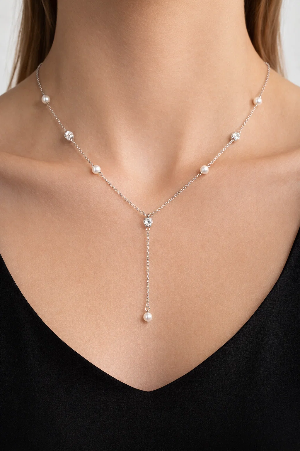 Model wearing an Alphalurent silver chain necklace featuring alternating white shell pearls and textured silver beads.