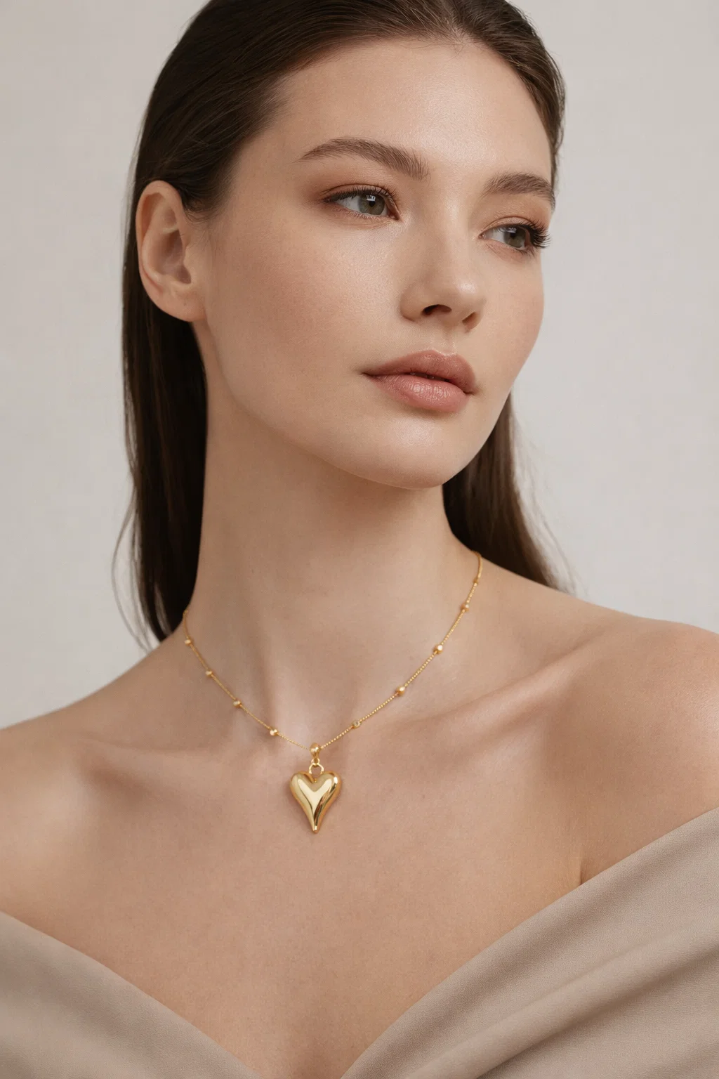 Gold Alphalurent titanium steel necklace featuring a smooth, 3D geometric heart pendant on a beaded snake chain.