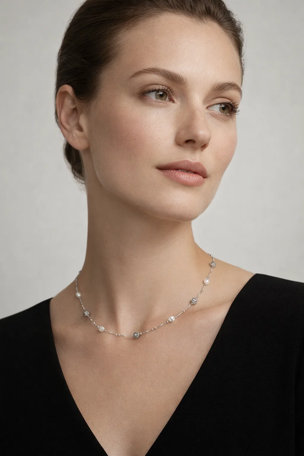 Model wearing an Alphalurent silver chain necklace featuring alternating white shell pearls and textured silver beads.