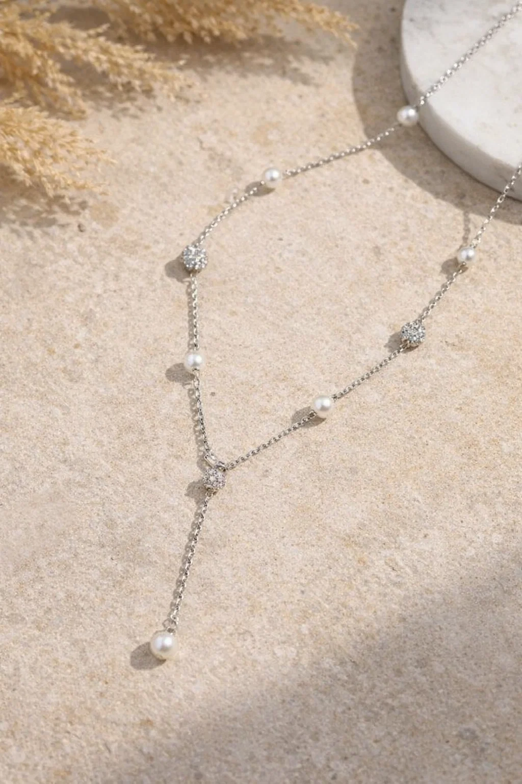 Model wearing an Alphalurent silver chain necklace featuring alternating white shell pearls and textured silver beads.