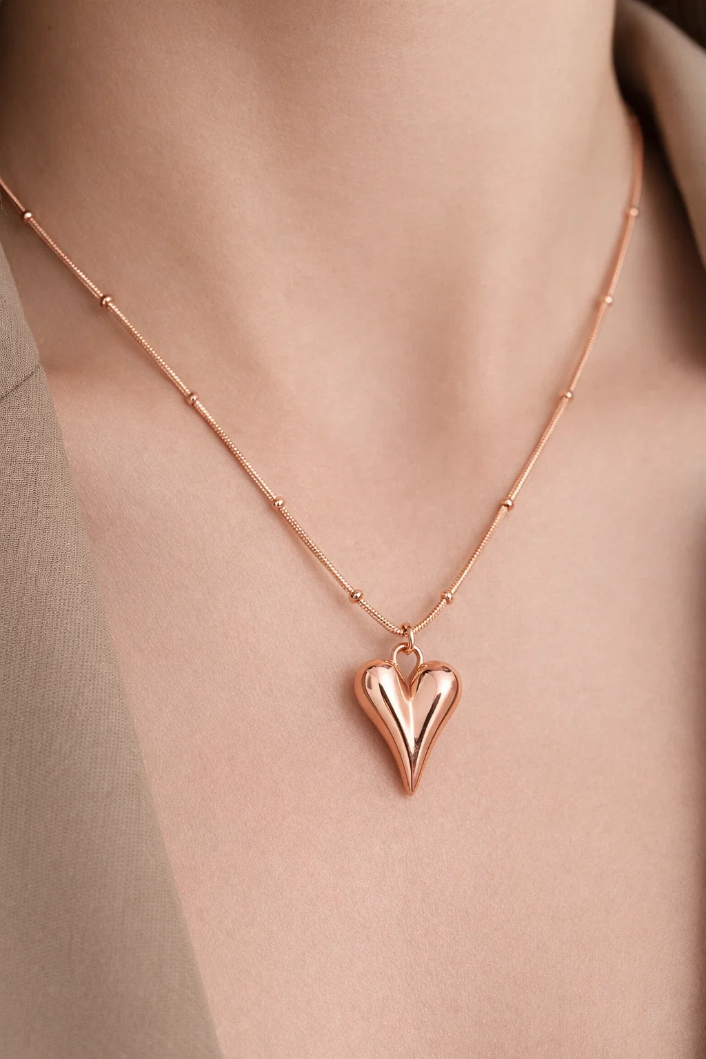 Gold Alphalurent titanium steel necklace featuring a smooth, 3D geometric heart pendant on a beaded snake chain.