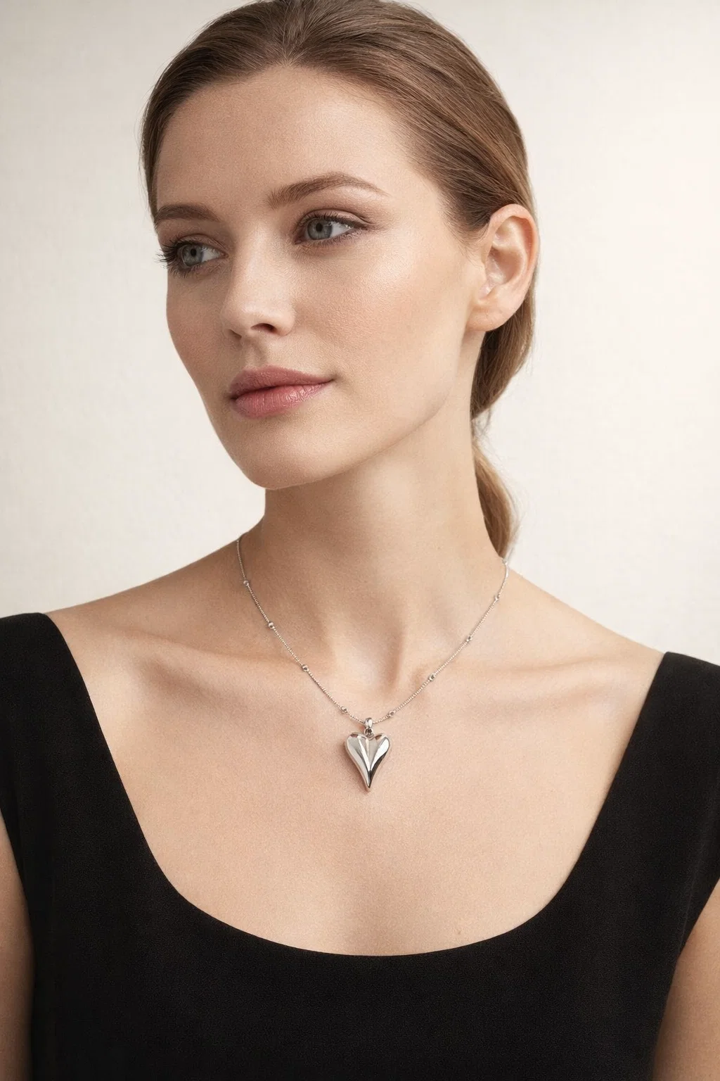 Gold Alphalurent titanium steel necklace featuring a smooth, 3D geometric heart pendant on a beaded snake chain.