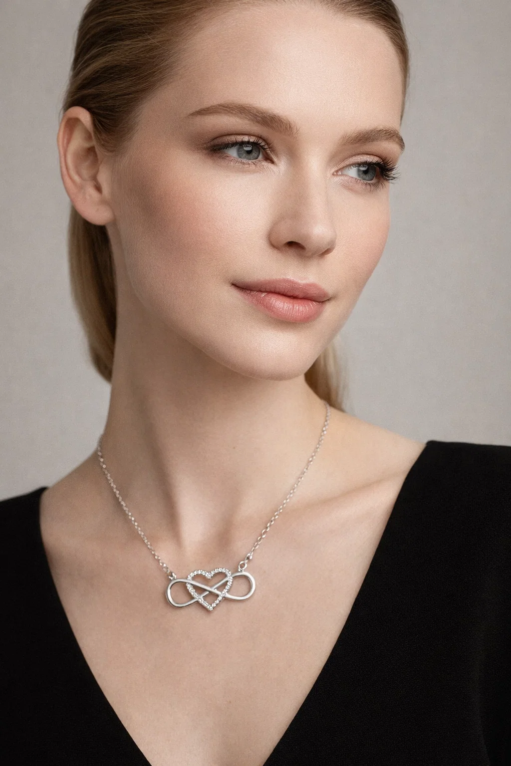 Close up of silver infinity heart pendant with zircon stone showing intricate design