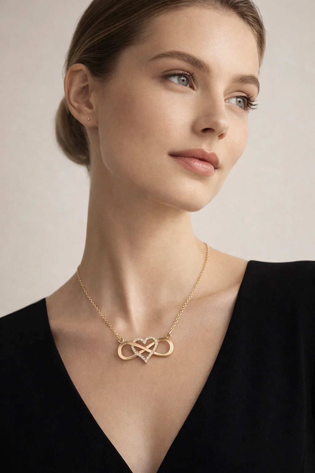 Infinity Lume gold plated necklace with infinity heart pendant and zircon center on velvet background