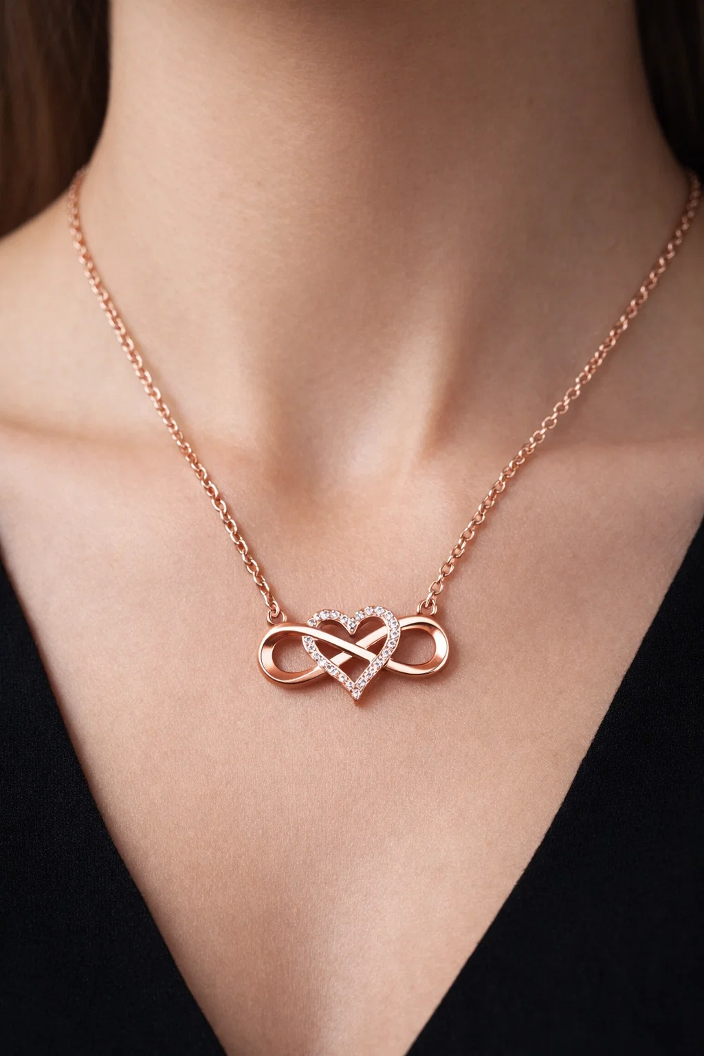 Rose gold infinity heart necklace with sparkling zircon worn with casual denim and white shirt
