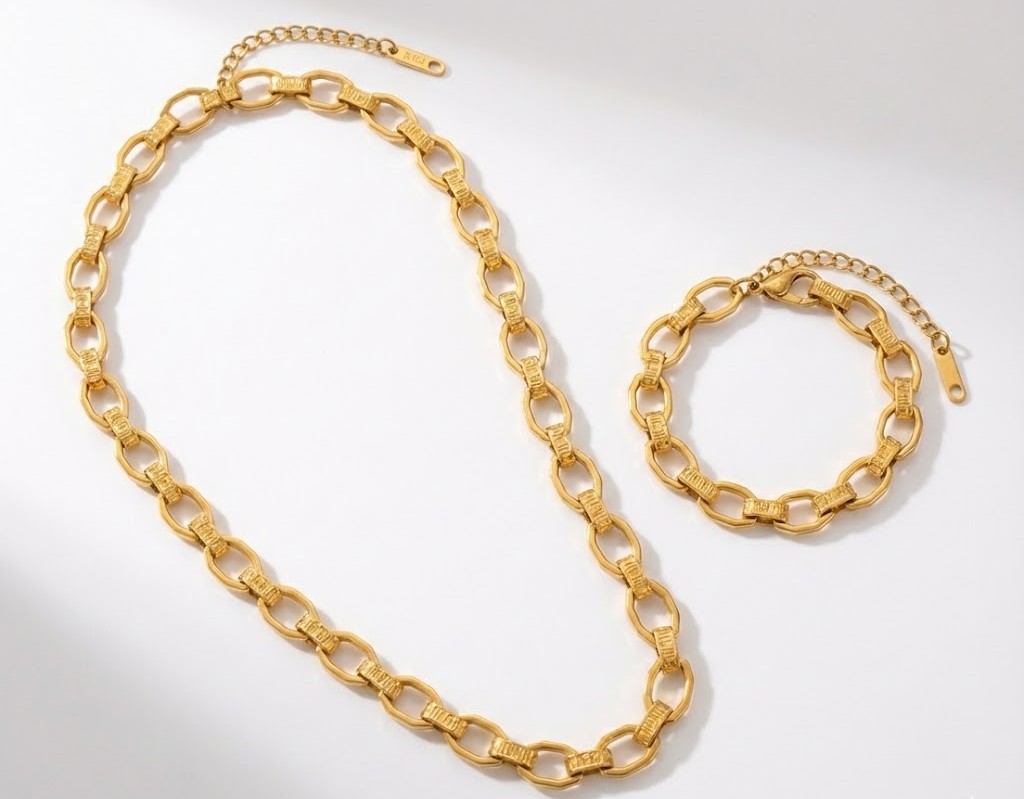 Alphalurent Textured Paperclip Link Chain | Gold Titanium Steel Necklace & Bracelet Alphalurent gold jewelry set featuring a chunky paperclip chain necklace and bracelet with a unique textured grid pattern on the links.