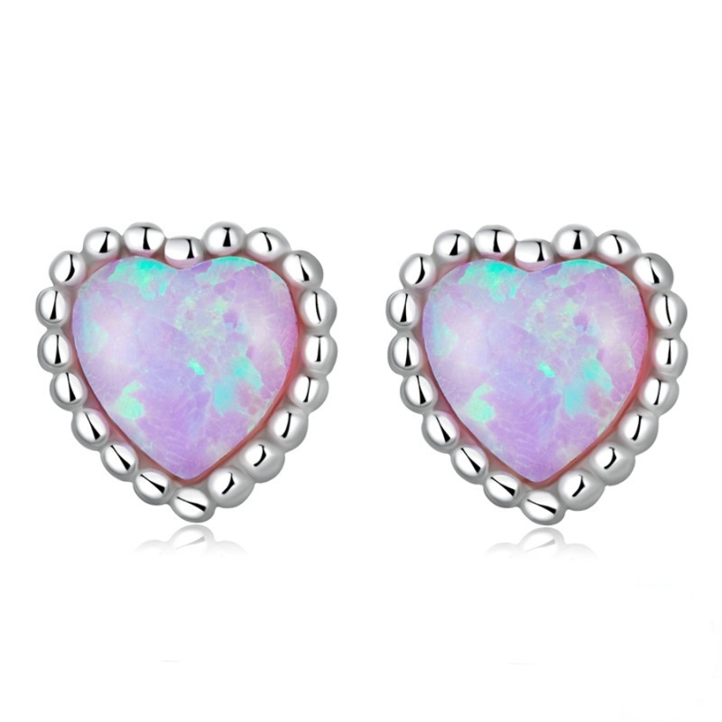 Alphalurent 925 sterling silver stud earrings featuring a heart-shaped iridescent blue opal crystal, a beaded silver edge, and comfortable screw-on ball backs.